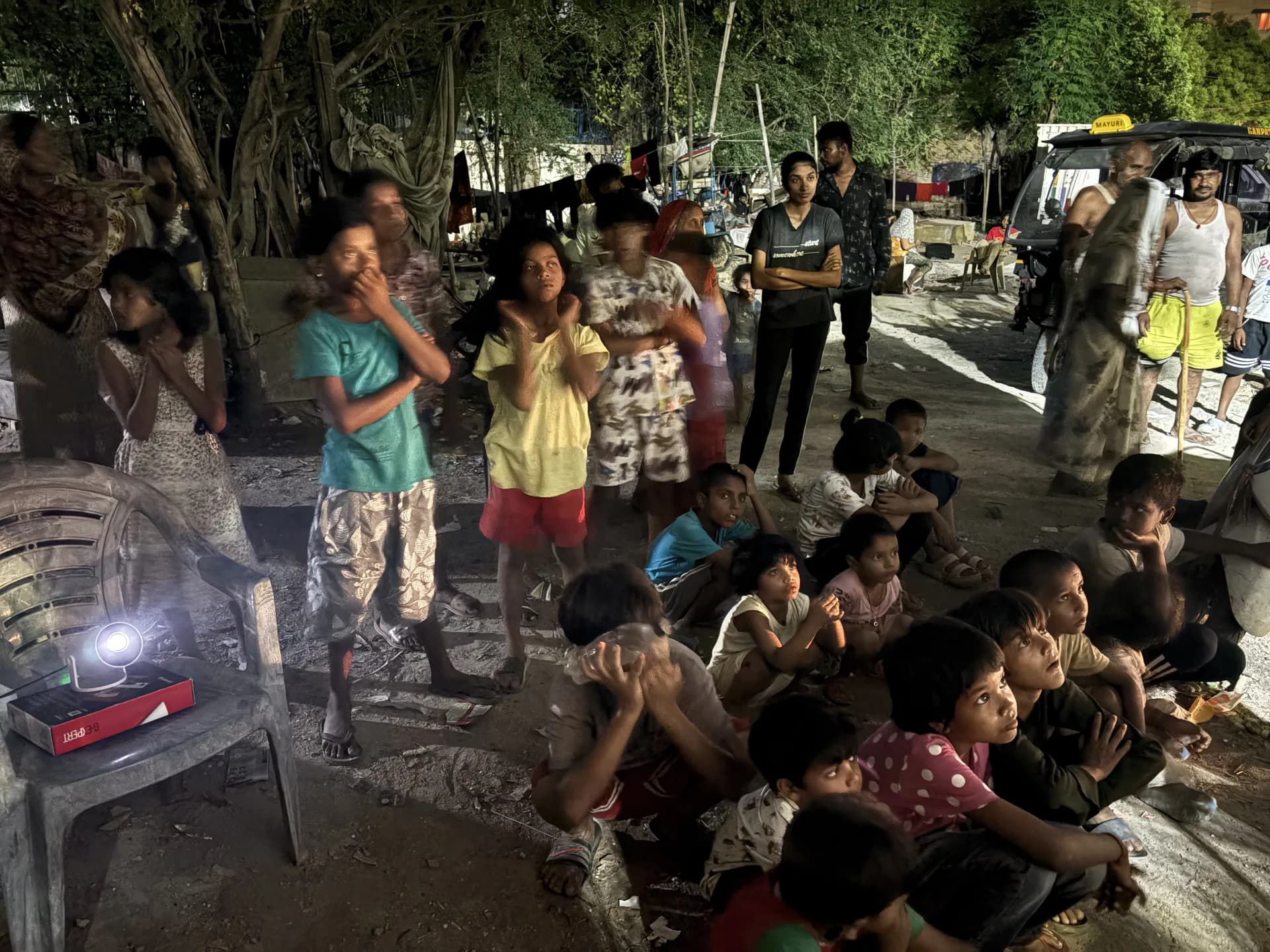 A portable projector lighting up faces in the crowd