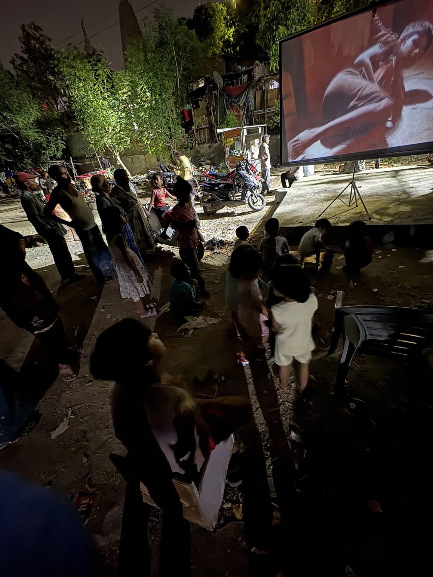 A film projected on a portable screen under the trees